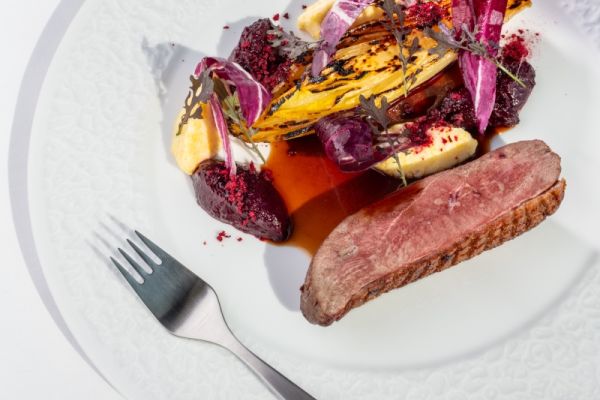 Duck breast with orange-braised chicory, creamy polenta and sour cherries